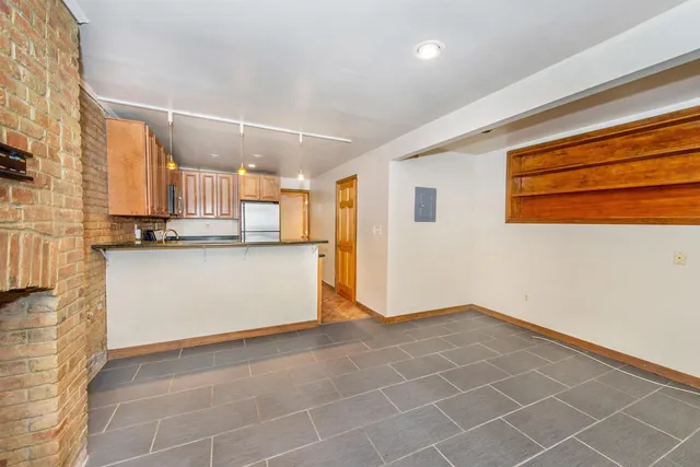 a view of a kitchen with wooden floor and cabinets