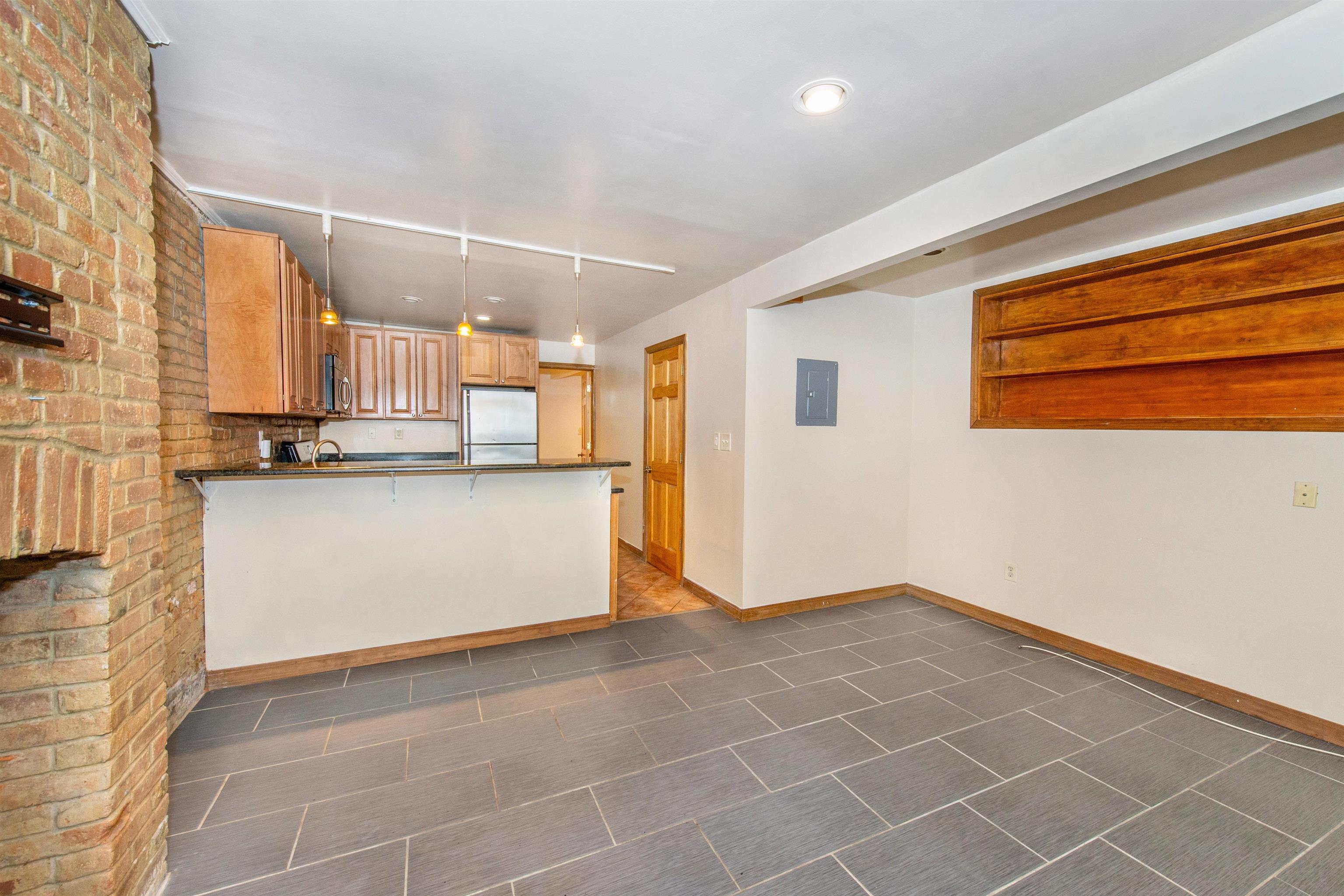 45 Monitor Street, Unit 1 Jersey City, NJ 07304 - Photo 6 of 14 a view of a kitchen with wooden floor and cabinets