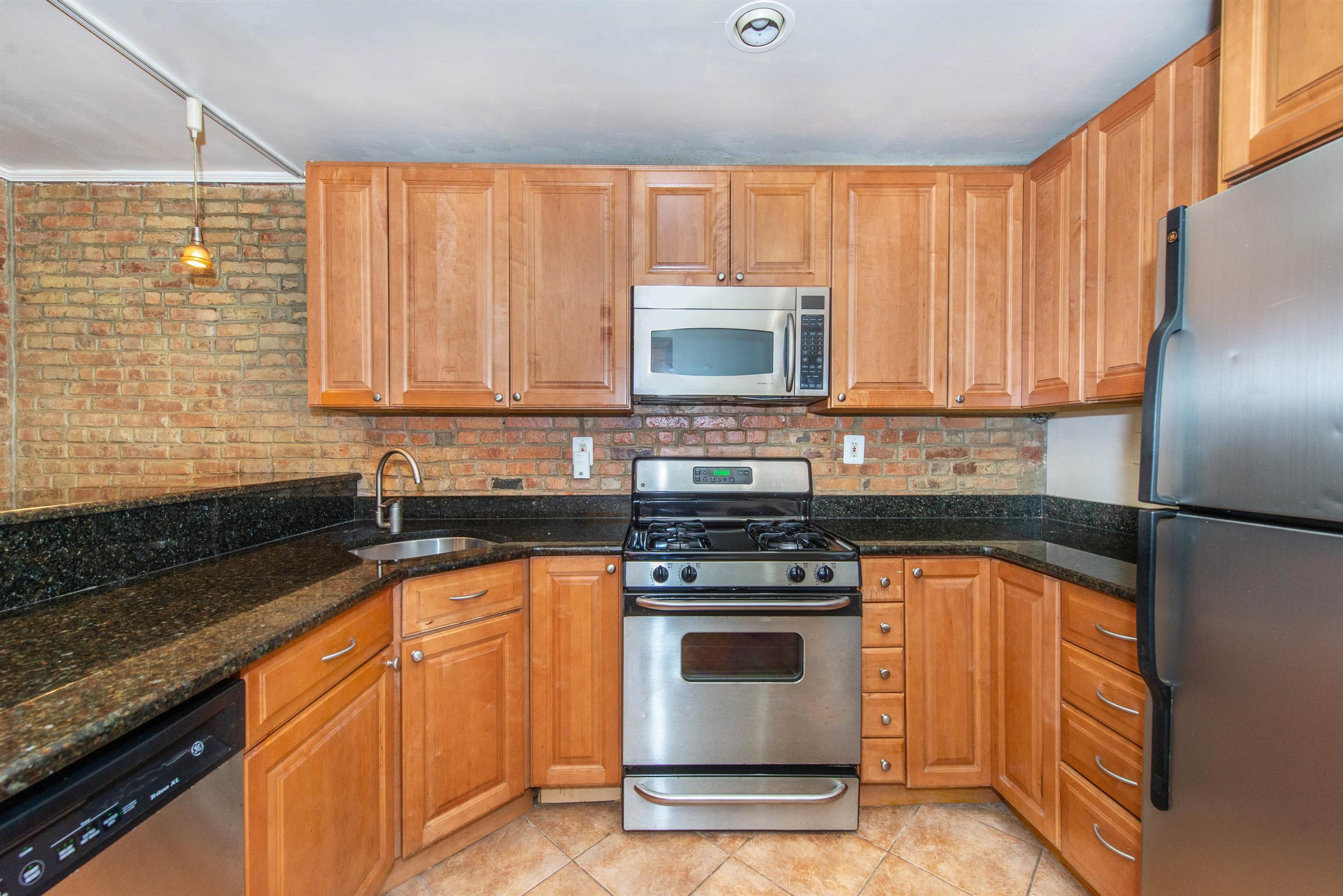 45 Monitor Street, Unit 1 Jersey City, NJ 07304 - Photo 9 of 14 a kitchen with stainless steel appliances granite countertop a stove a sink and a microwave