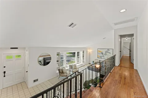 a view of a hallway with wooden floor and windows