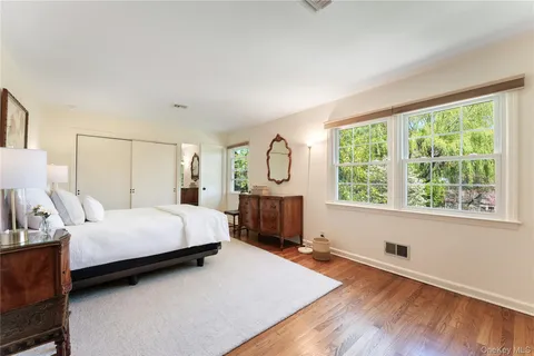 a bed room with a bed a dresser and a window
