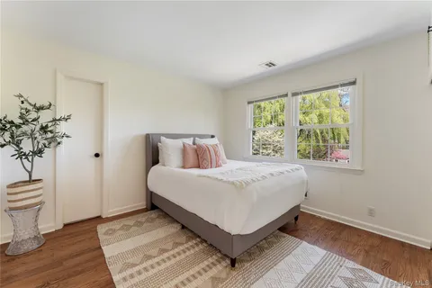 a bedroom with a bed and a potted plant