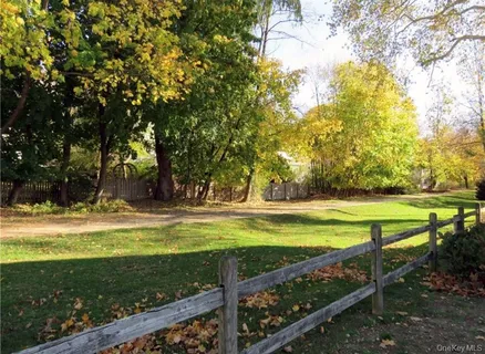 a view of a yard with swimming pool and green space