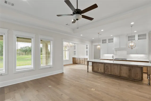 a large kitchen with kitchen island a large window a sink and stainless steel appliances