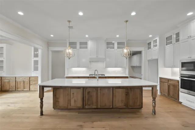 a kitchen with kitchen island a sink stainless steel appliances and cabinets