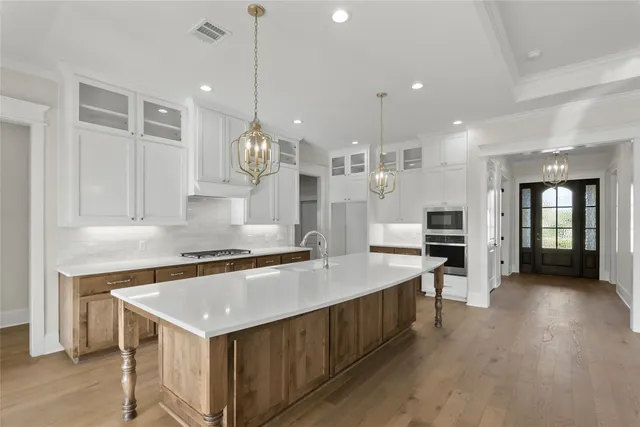 a kitchen with a stove a sink a center island and a window