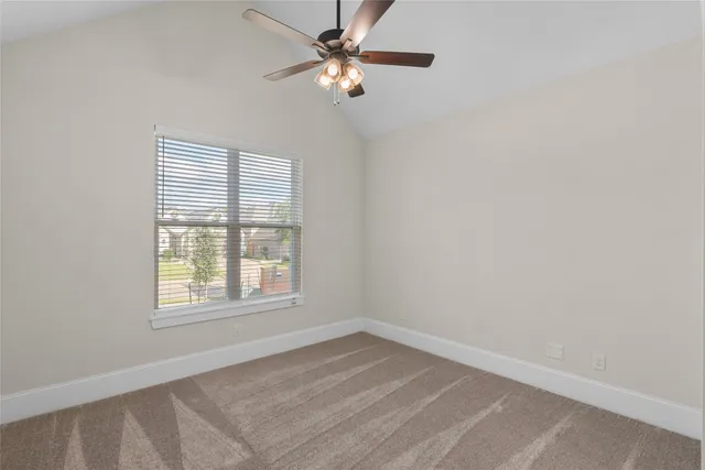 an empty room with a window and a fan
