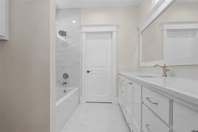 a spacious bathroom with a granite countertop sink a mirror and a bathtub