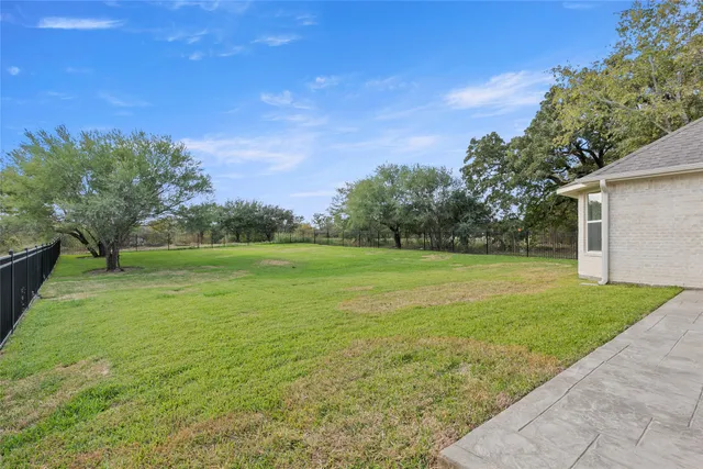 a view of a house with a big yard and large tree
