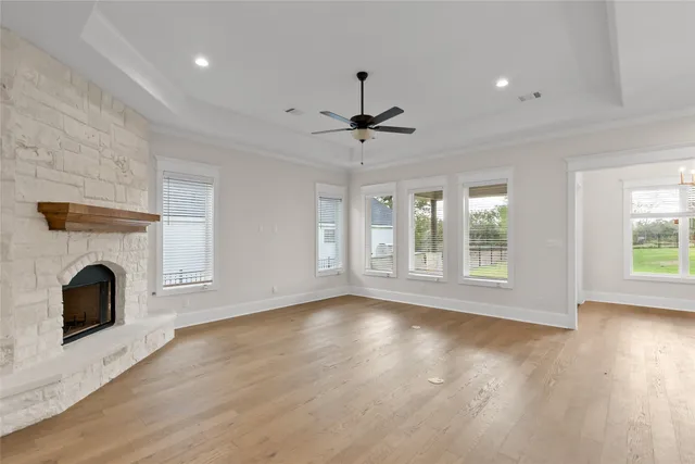 a view of empty room with fireplace and wooden floor