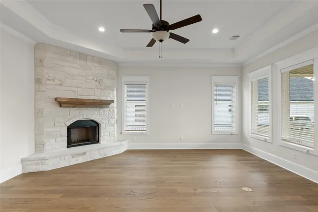 an empty room with windows and fireplace