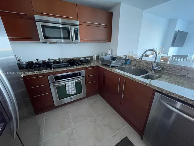 a kitchen with stainless steel appliances granite countertop a sink and a stove