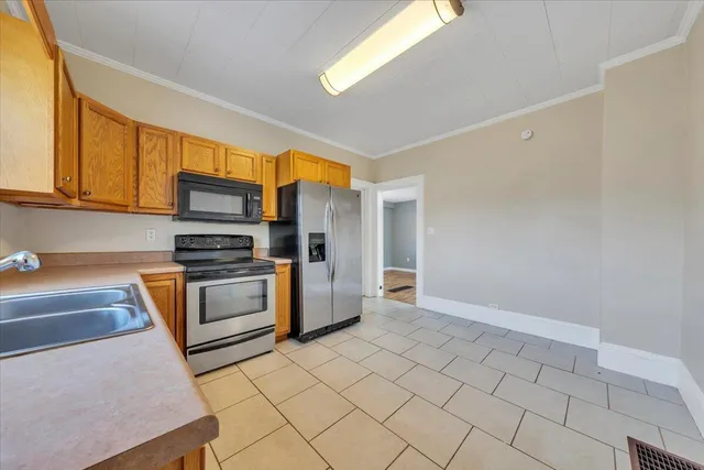 a kitchen with granite countertop a stove a sink and a refrigerator