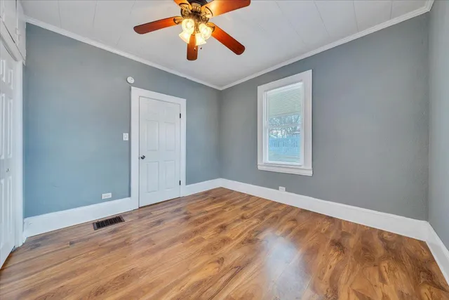 a view of an empty room with window and closet area