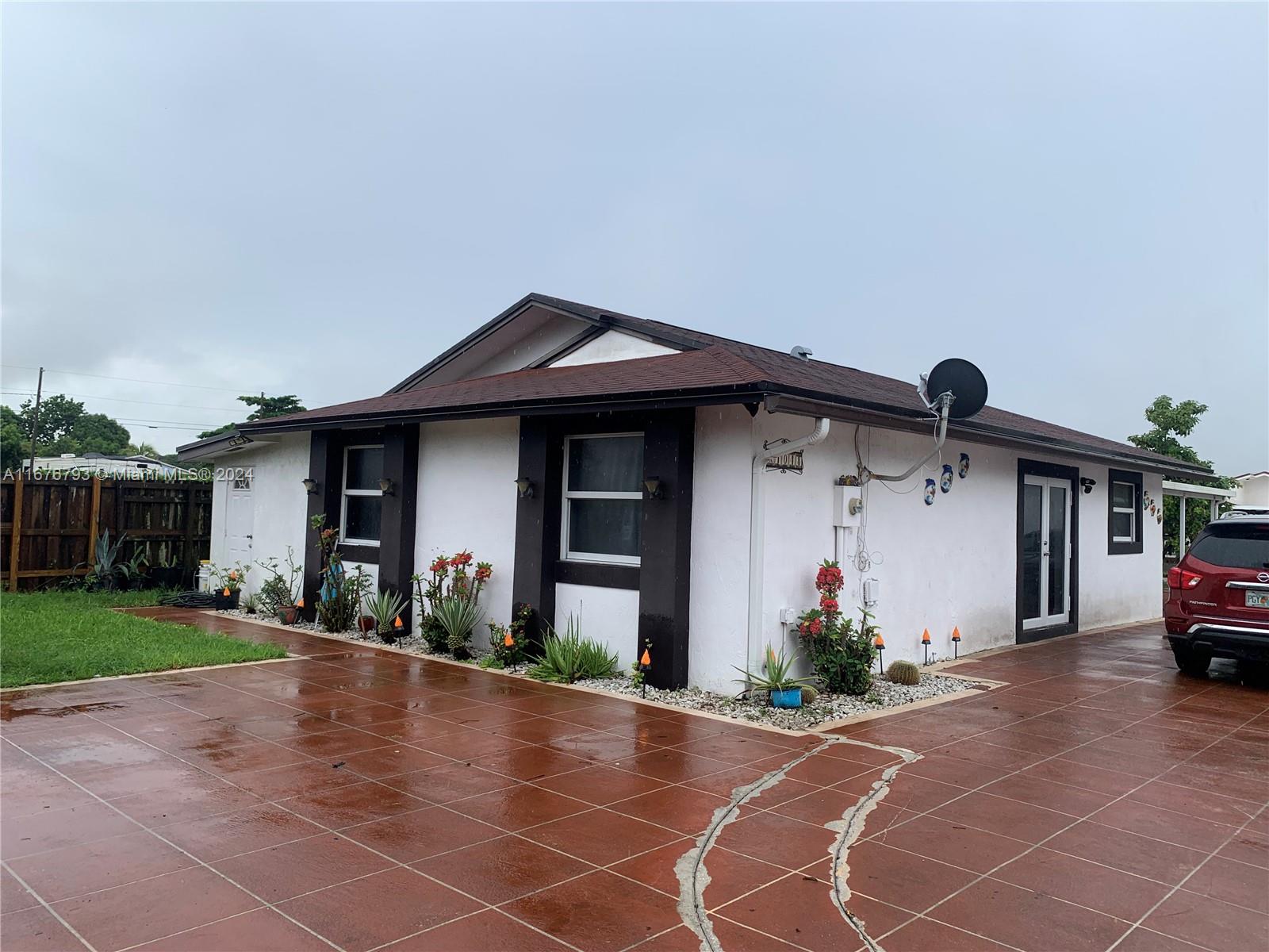 21048 Southwest 118th Place Miami, FL 33177 - Photo 2 of 26 a front view of a house with a yard and garage