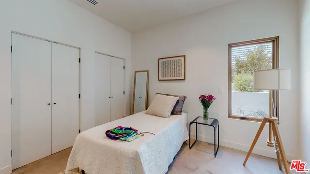 a bedroom with a bed and a potted plant