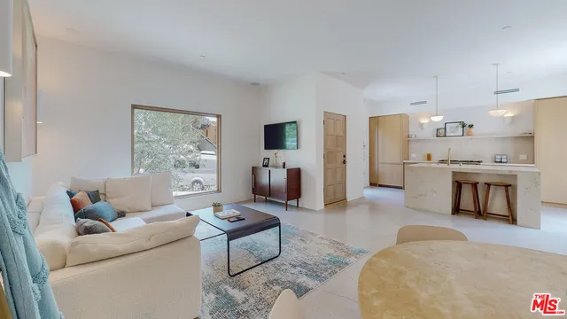 a living room with furniture and a kitchen