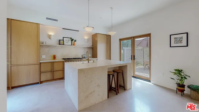 a kitchen with stainless steel appliances granite countertop a refrigerator a sink a stove and a wooden floors