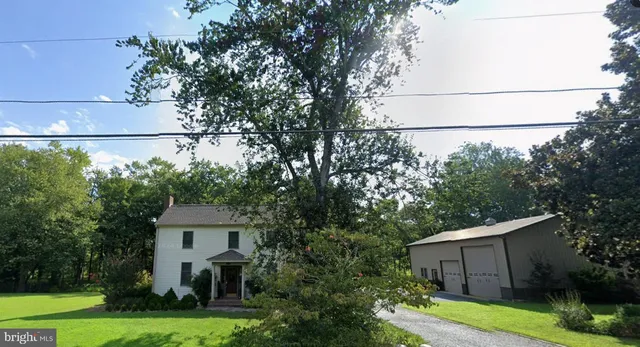 a view of a house with a yard and large trees