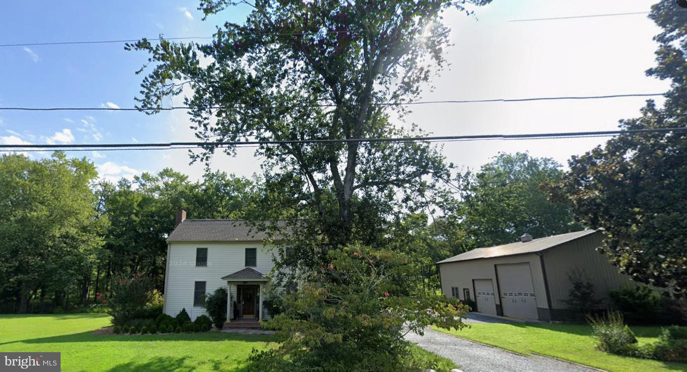 a view of a house with a yard and large trees