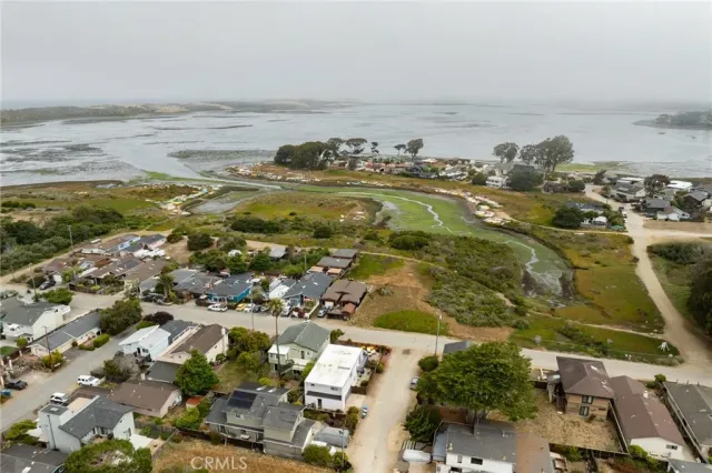an aerial view of ocean and residential houses with outdoor space