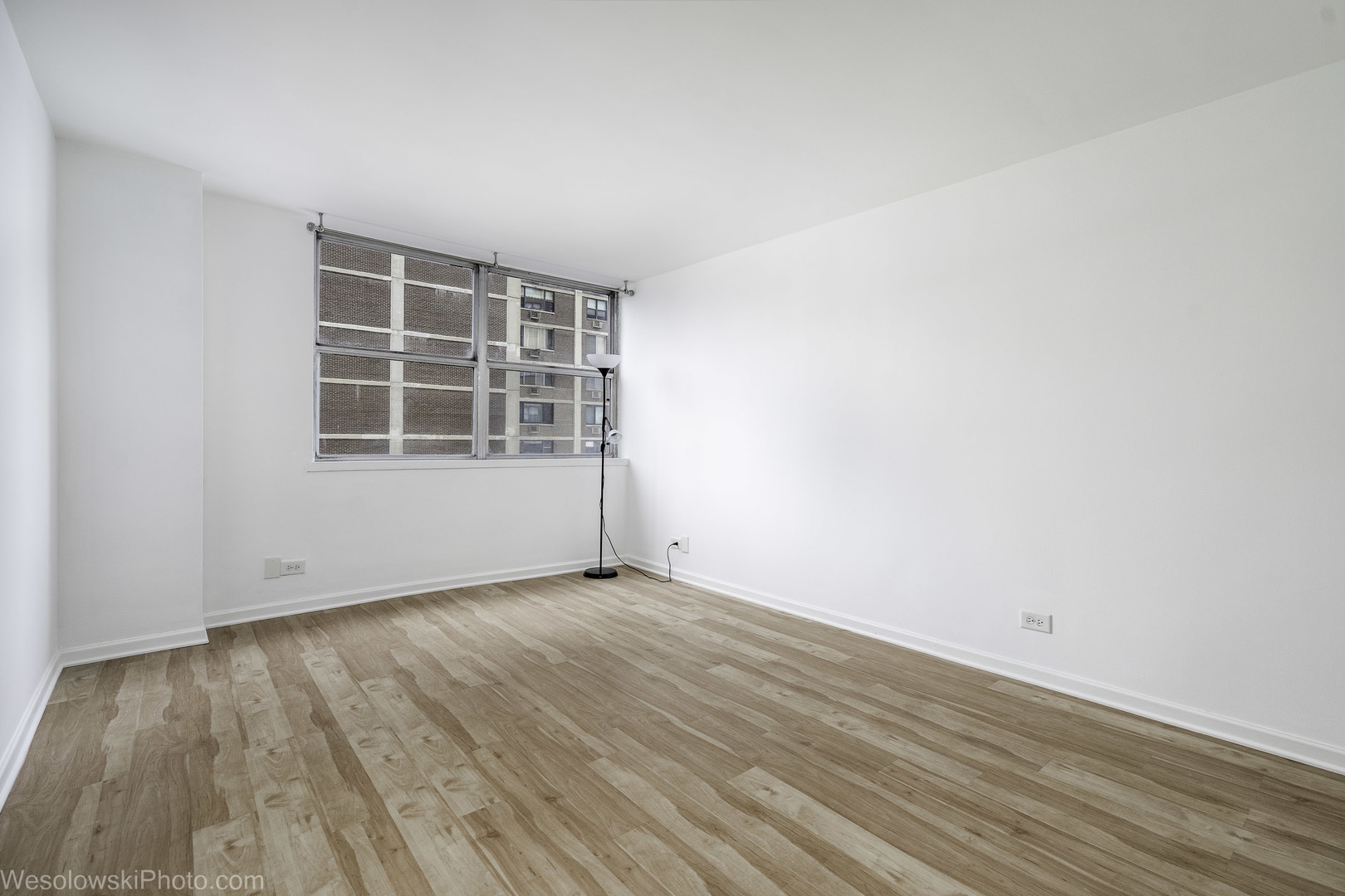 6301 North Sheridan Road, Unit 6C Chicago, IL 60660 - Photo 7 of 20 an empty room with wooden floor and windows