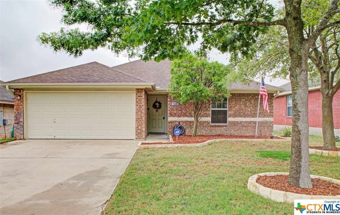 128 Calcite Lane Jarrell, TX 76537 - Photo 1 of 1 a front view of a house with a yard garage and chairs