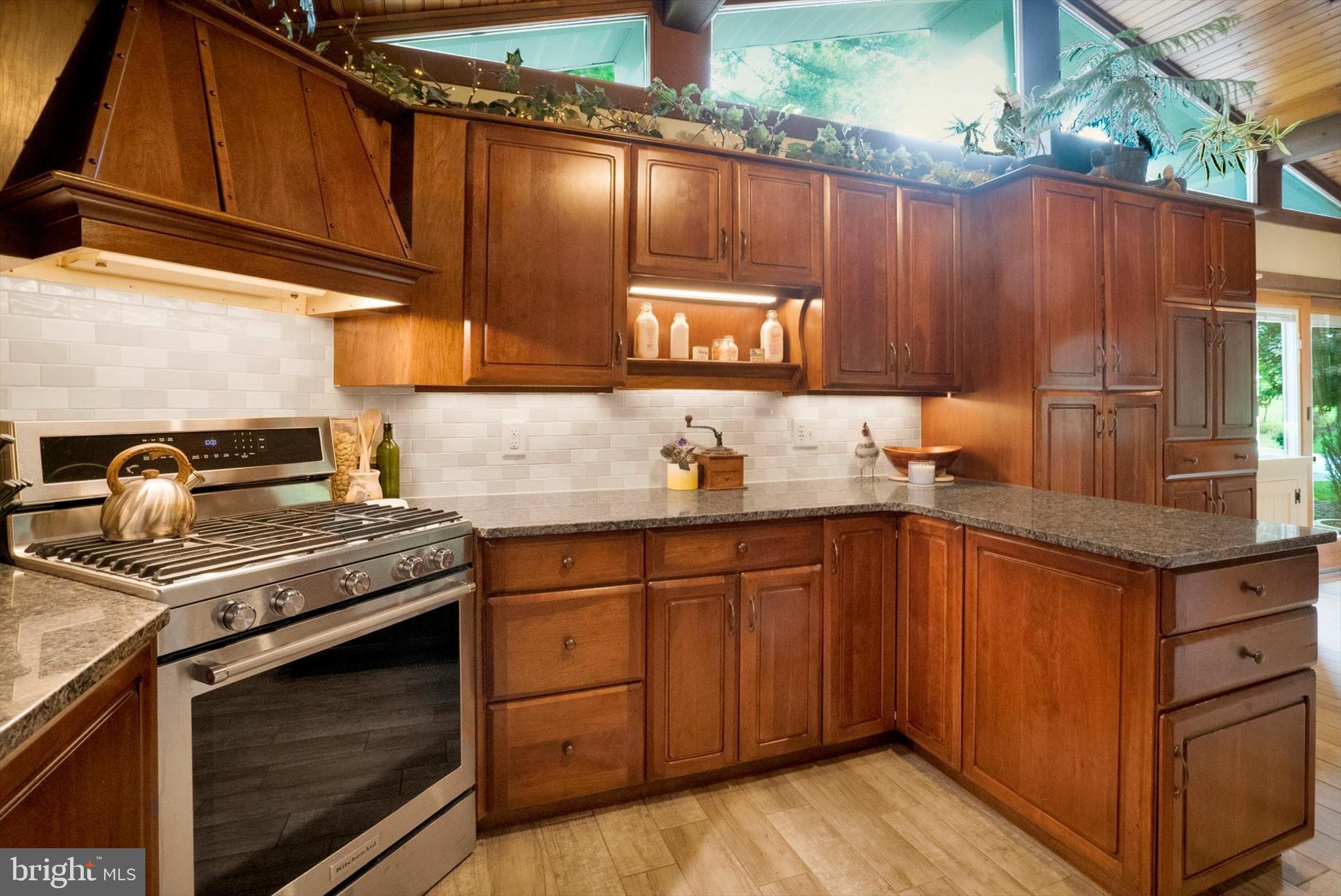 53 Main Street Oley, PA 19547 - Photo 14 of 26 a kitchen with granite countertop a stove top oven cabinetry a sink and a refrigerator