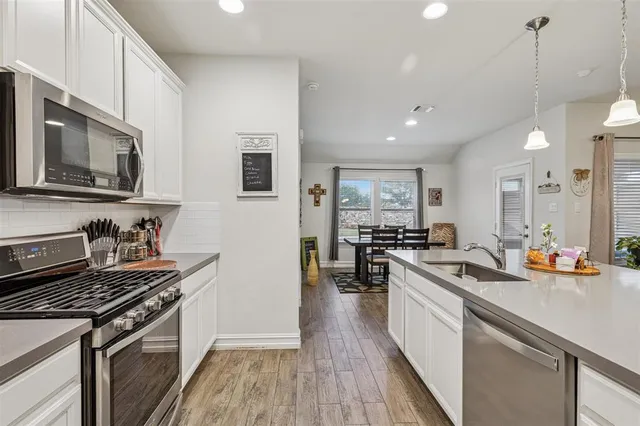 a kitchen with stainless steel appliances a stove sink microwave and cabinets