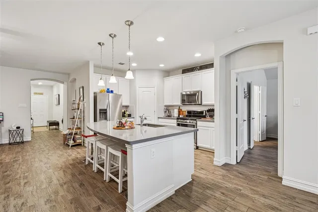 a kitchen with kitchen island a sink stove and refrigerator