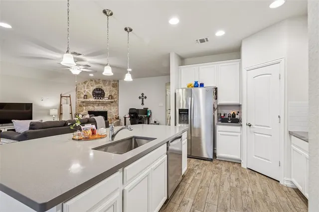 a kitchen with kitchen island a sink appliances and cabinets