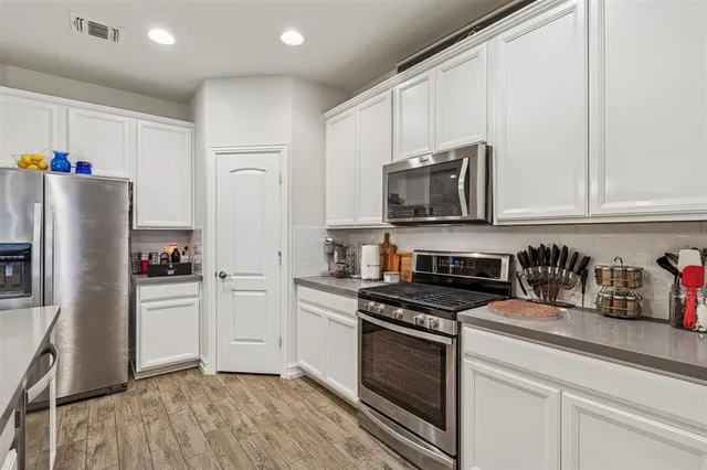 a kitchen with stainless steel appliances granite countertop a refrigerator stove and microwave