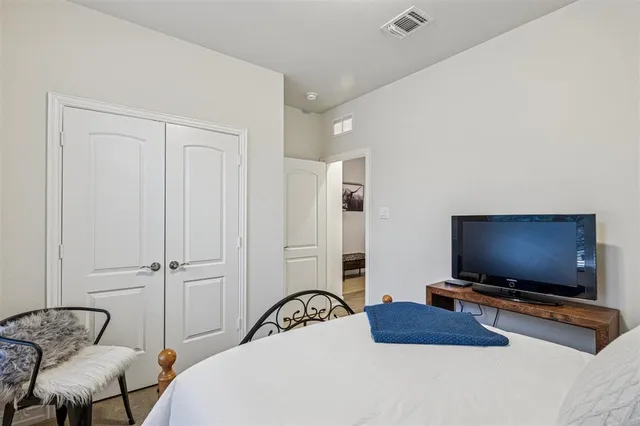 a bedroom with furniture and a flat screen tv