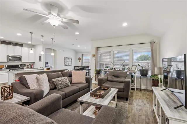a living room with furniture kitchen view and a large window