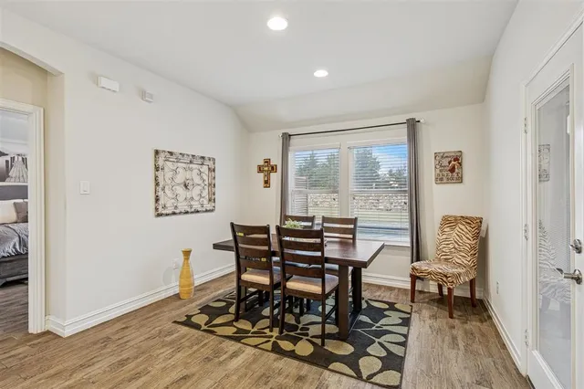 a dining room with wooden floor and a floor to ceiling window