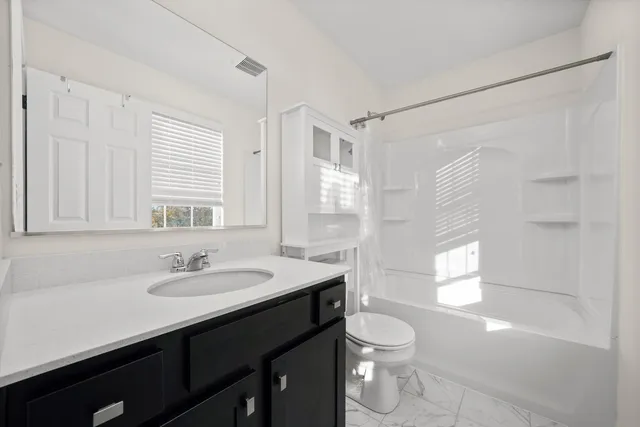 a bathroom with a sink toilet a mirror and shower