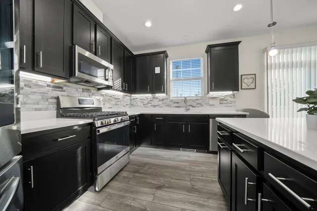 a kitchen with stainless steel appliances granite countertop counter space a sink and cabinets