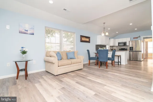 a living room with furniture and a dining table with kitchen view