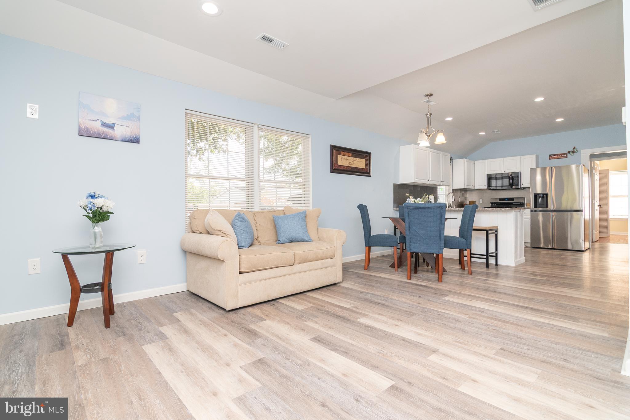 a living room with furniture and a dining table with kitchen view