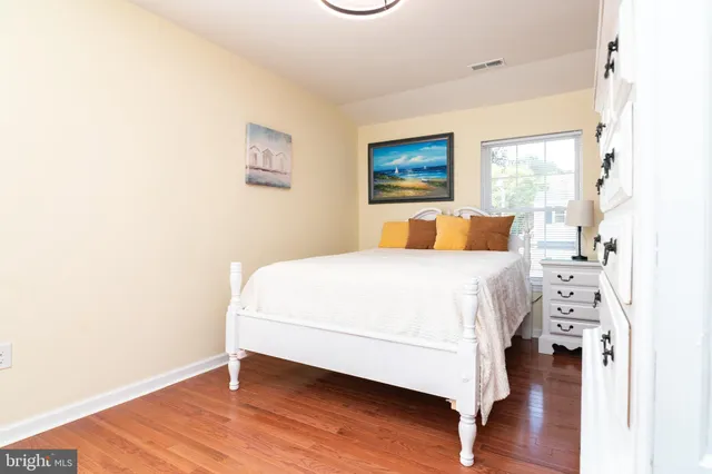 a bedroom with a bed and a painting on the wall