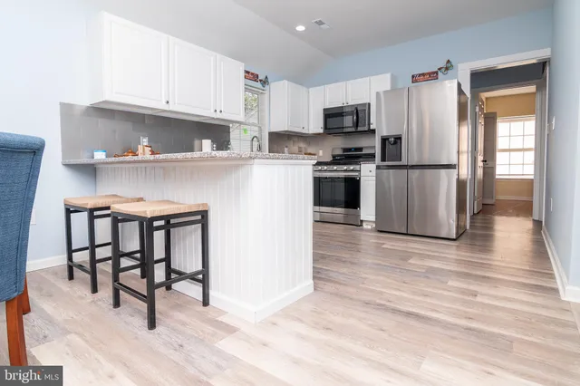 a kitchen with granite countertop a refrigerator stove top oven and sink