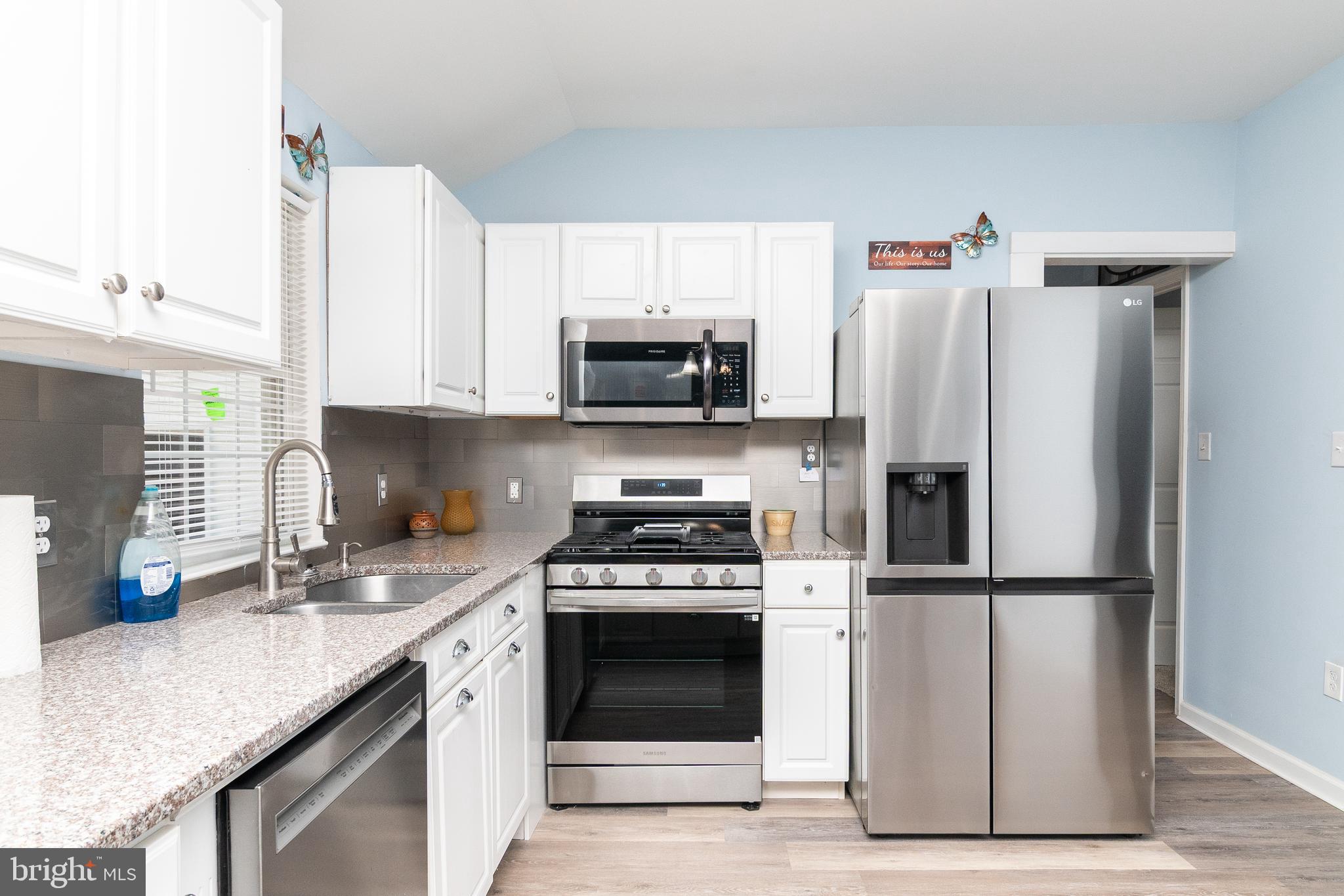 1154 West 6th Street Laurel, DE 19956 - Photo 7 of 27 a kitchen with granite countertop a stove sink and refrigerator