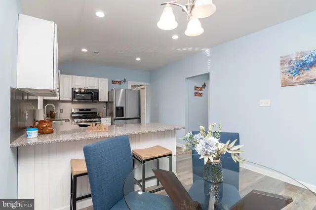 a kitchen with stainless steel appliances granite countertop a refrigerator sink cabinets and wooden floor