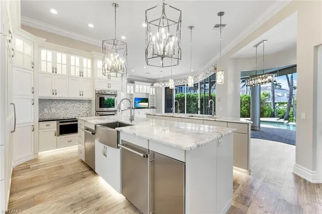 a kitchen with stainless steel appliances granite countertop a stove a sink and a refrigerator