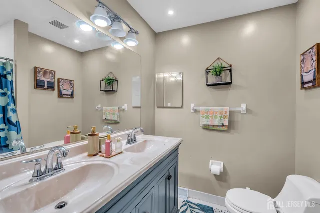 a bathroom with a sink vanity mirror and toilet