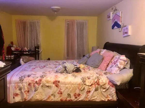 a bedroom with a bed and a dresser with rug