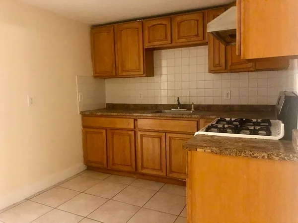 a kitchen with granite countertop a sink stove and cabinets