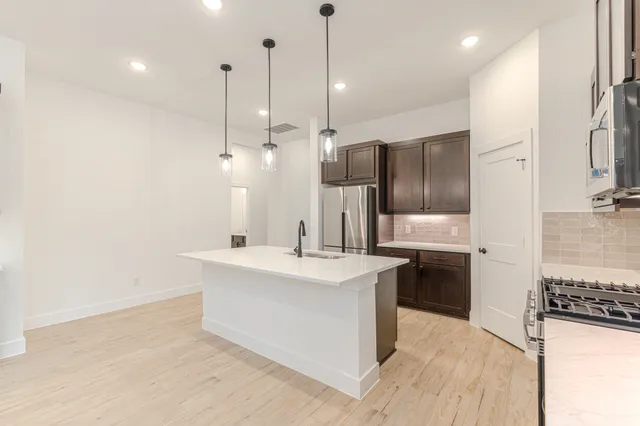 a large kitchen with kitchen island a sink stainless steel appliances and a counter top