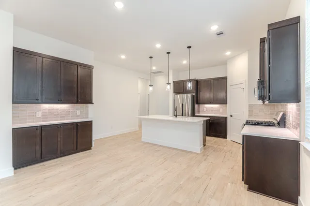 a large kitchen with kitchen island a sink stainless steel appliances and cabinets