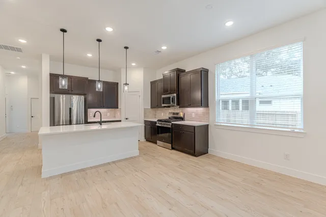 a large kitchen with a large window and stainless steel appliances